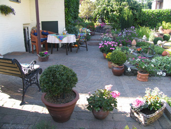 Garten planen: Beispiel einer Terrasse mit vielen bepflanzten Gef&auml;&szlig;en