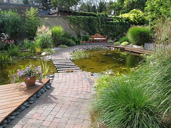 Traumgarten mit Teich und Trittsteinen über das Wasser