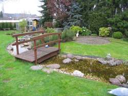 Holzbr&uuml;cke &uuml;ber den Bachlauf im Garten