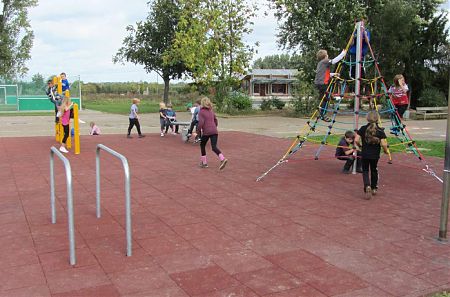 Spielplatzgestaltung, Kinder spielen auf Geräten auf Fallschutzplatten