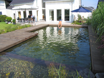 Kopfsprung von angrenzender Terrasse direkt in den Schwimmteich