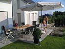 terrasse mit großer Sitzgruppe und Sonnenschirm