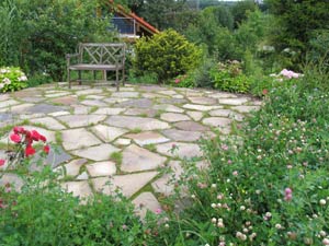 Terrasse mit Polygonalplatten in Blumenwiese